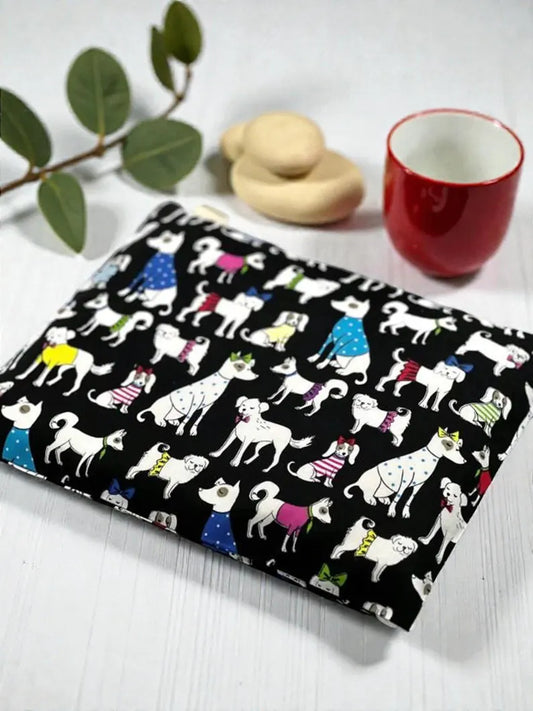 Notebook with dog pattern on a white surface with a red mug and cookies.