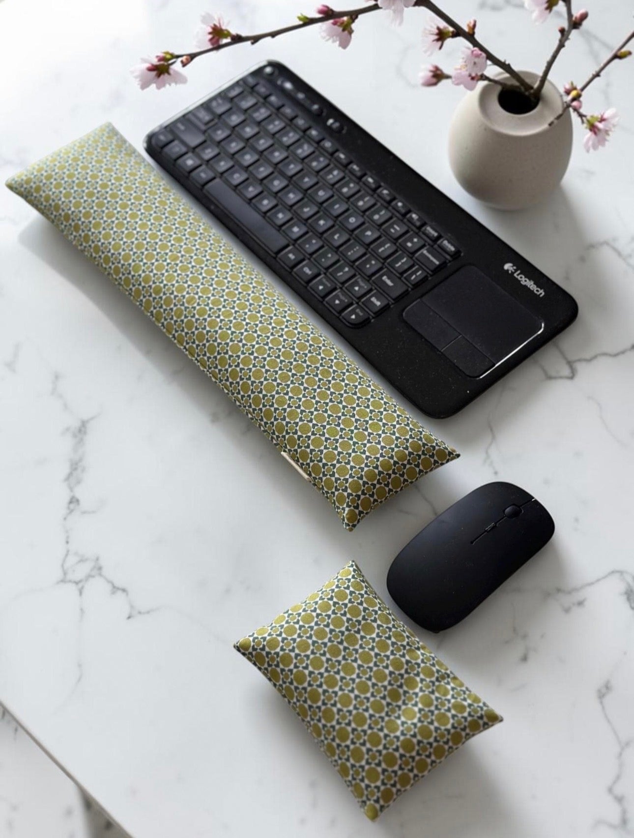Keyboard and mouse wrist rest set in olive green geometric print fabric on marble surface