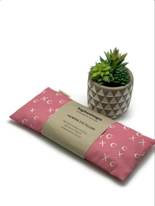 pink fabric eye pillow with x's and o's