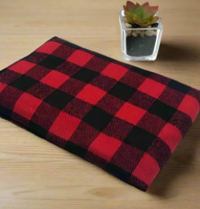 Handmade red and black buffalo plaid flannel heating and cooling pad displayed with a small succulent plant on a wooden surface