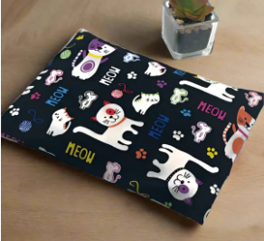 Handmade navy cat print cotton heating and cooling pad with colorful cartoon cats and MEOW text, displayed with a small succulent plant on a wooden surface