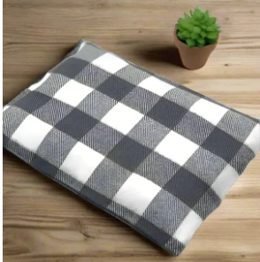 Handmade gray and white buffalo plaid flannel heating and cooling pad displayed with a small succulent plant on a wooden surface