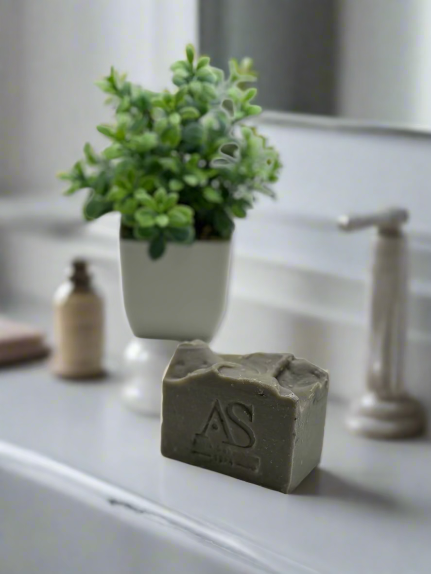 Clay soap with a small greens on a pot as a background decoration