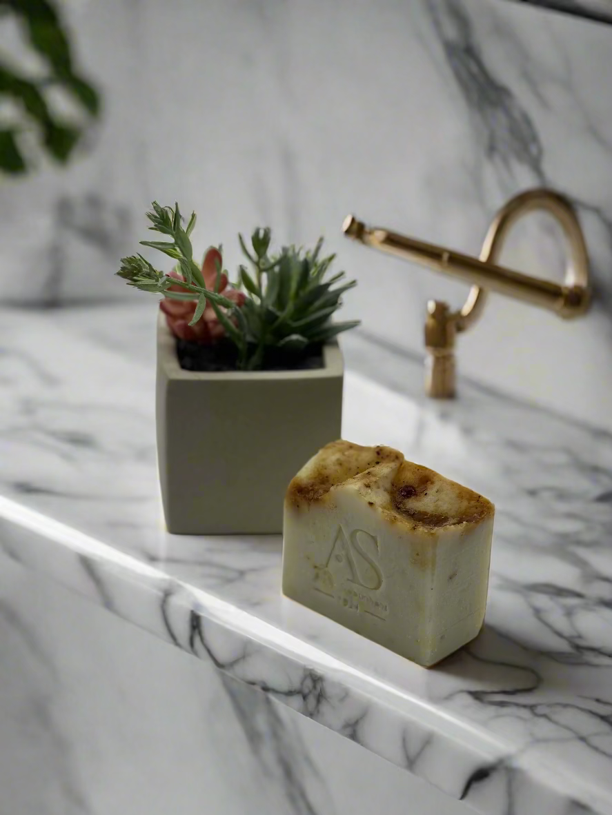 Bar of soap with a plant on a gray background