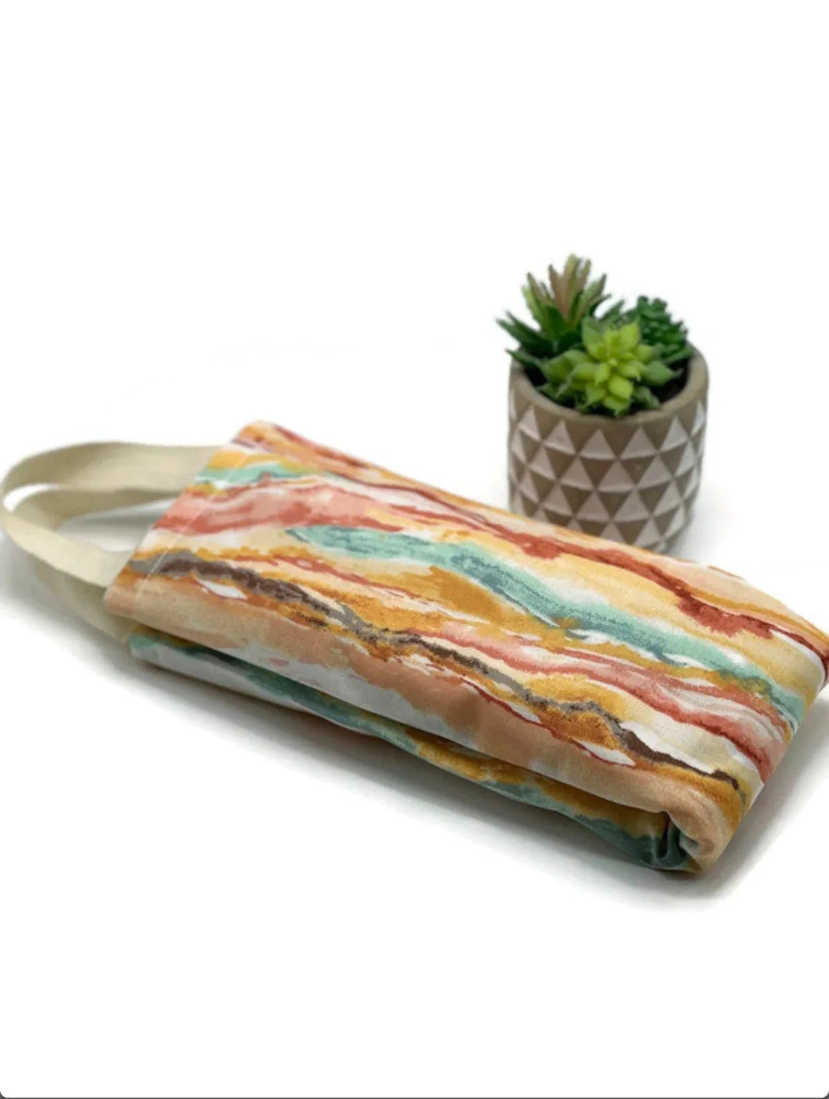 NagihanDesigns flaxseed neck wrap in watercolor rainbow cotton fabric with soft brushstroke patterns and carry handles