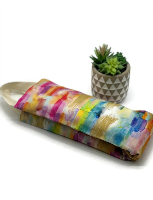 NagihanDesigns flaxseed neck wrap in watercolor rainbow cotton fabric with painterly brushstrokes on a white background