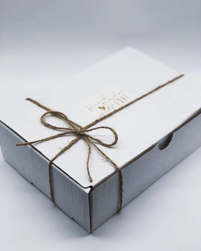 A white gift box neatly wrapped with twine string tied in a bow